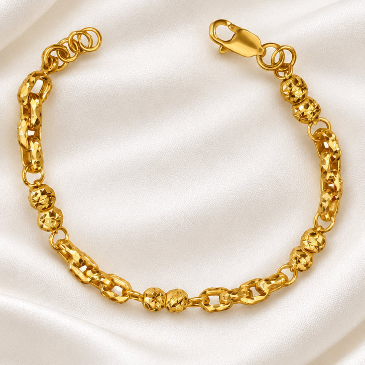 916 gold Wan Zi ball bracelet viewed from above with its clasp open on cream satin