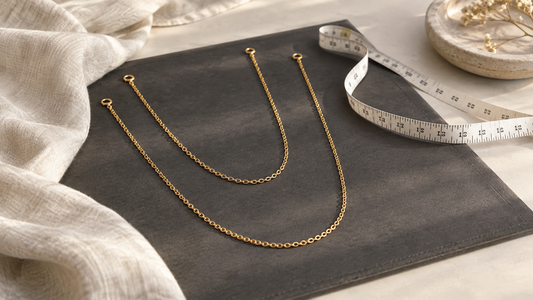 Two generic gold chains of different lengths beside a measuring tape