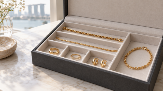 Generic yellow-gold jewellery stored separately in a soft-lined jewellery organizer, with chains laid flat.