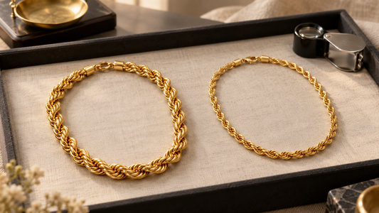 Two generic yellow-gold rope chains of different weights displayed side by side on an ivory jeweller’s tray.
