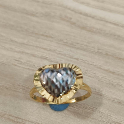 Front view of a 916 gold two-tone heart ring with a textured silver-coloured heart and gold border on pale wood