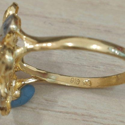 Close-up of the 916 stamp inside the band of a gold two-tone floral cluster ring