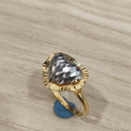 Angled view of a 916 gold two-tone heart ring showing its textured heart detail and slim gold band