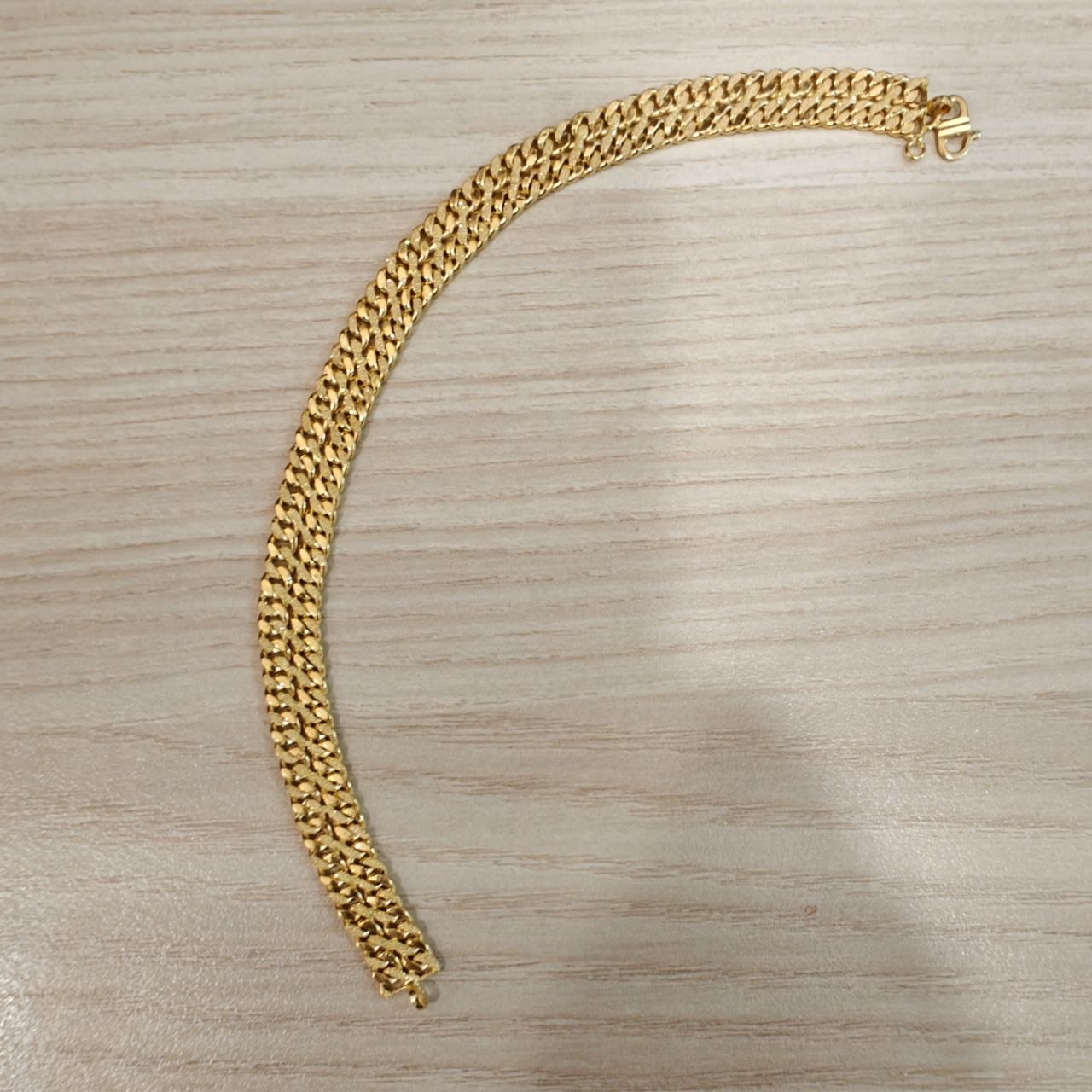 Close-up texture of 22K gold Cowboy chain bracelet.