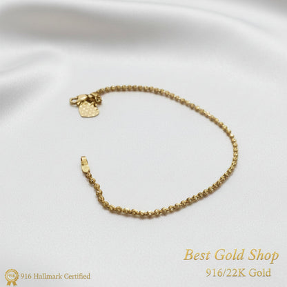 Close-up of heart charm on a 22K Gold solid bead bracelet.