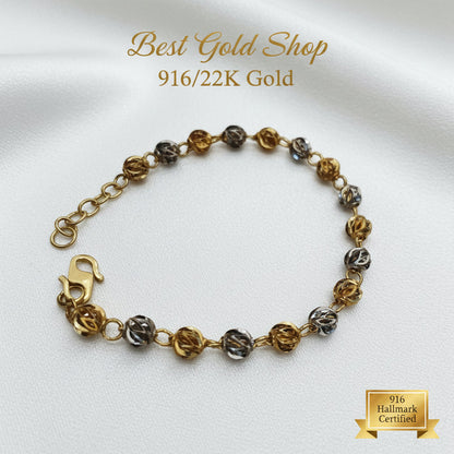 Close-up of two-tone faceted balls on a 22K Gold bracelet.