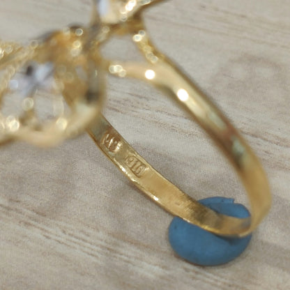 Close-up of the 916 stamp inside the gold band of a two-tone butterfly ring