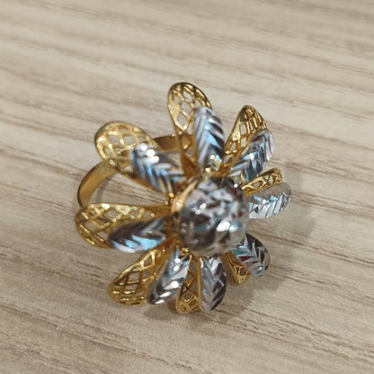 Angled front view of a 916 gold two-tone daisy ring with openwork gold petals and faceted silver-coloured details