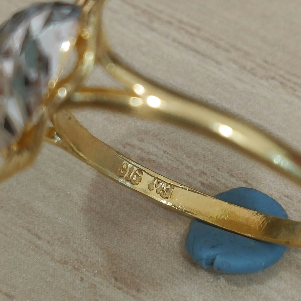 Close-up of the 916 stamp inside the gold band of a two-tone heart ring