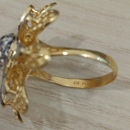 Close-up of the 916 stamp inside the gold band of a two-tone daisy ring