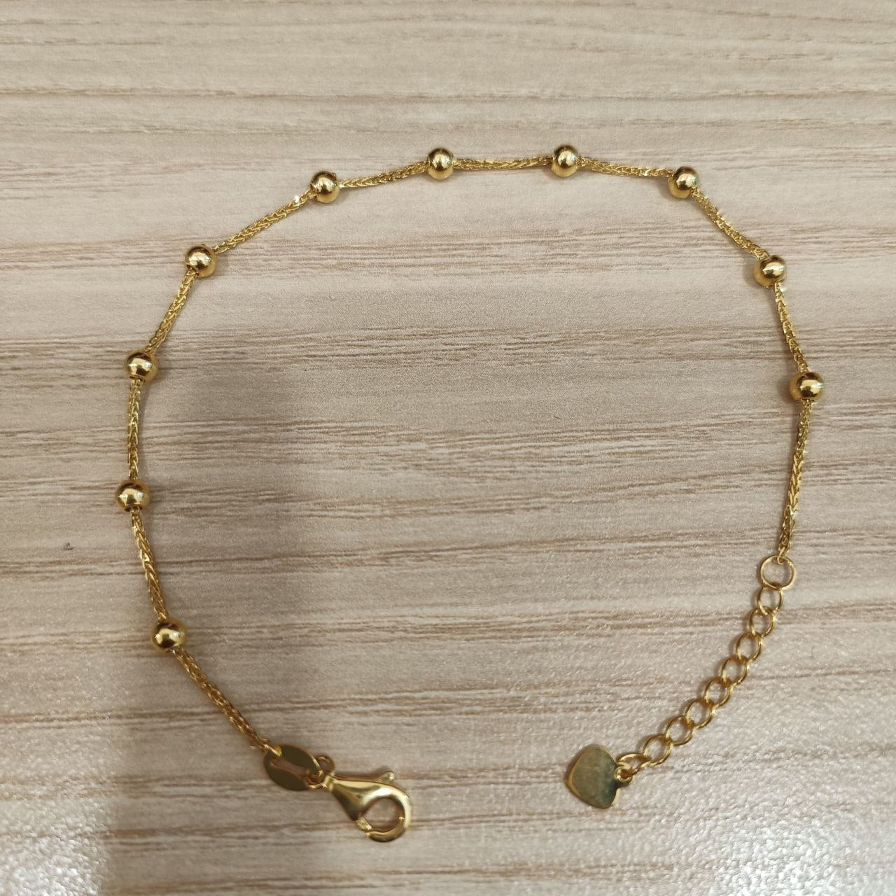 916 gold bead station bracelet laid flat with extender chain