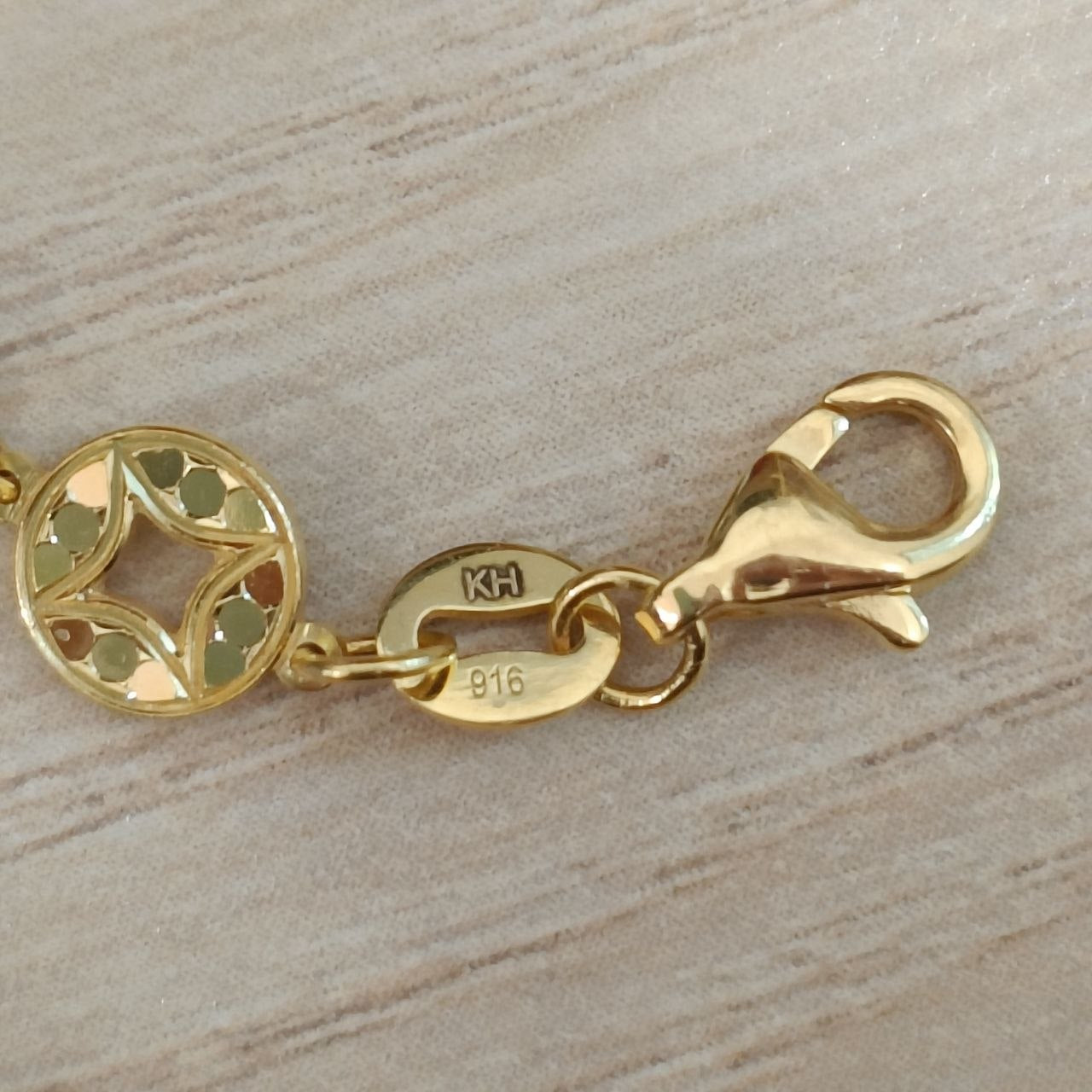 Close-up of KH and 916 markings beside the lobster clasp