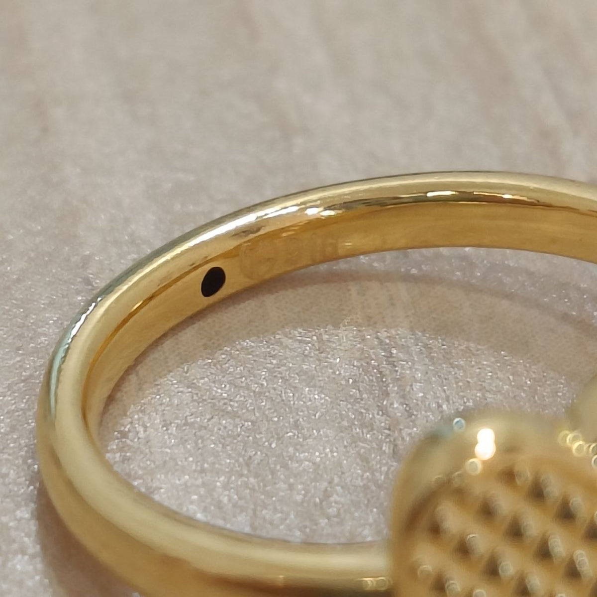 Close-up detail of 916 gold cross heart ring band