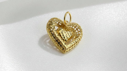 Front view of the 916 gold dangling heart pendant on white satin, showing the faceted openwork heart frame, smaller suspended heart and complete round bail