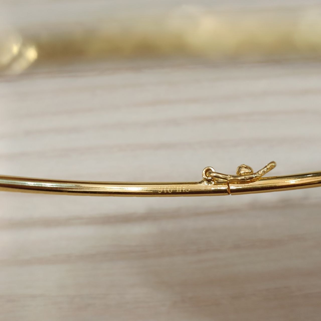 Close-up of the 22K gold slim bangle and diamond-cut finish