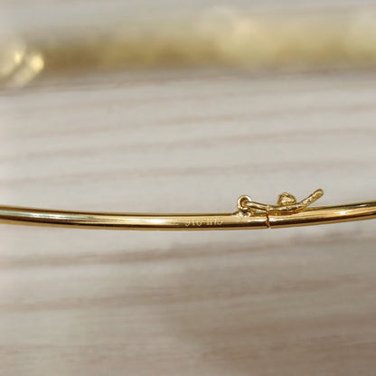 Close-up of the 22K gold slim bangle and diamond-cut finish