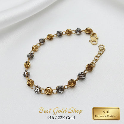 Detailed view of polished faceted beads on a 916 Gold two-tone bracelet.