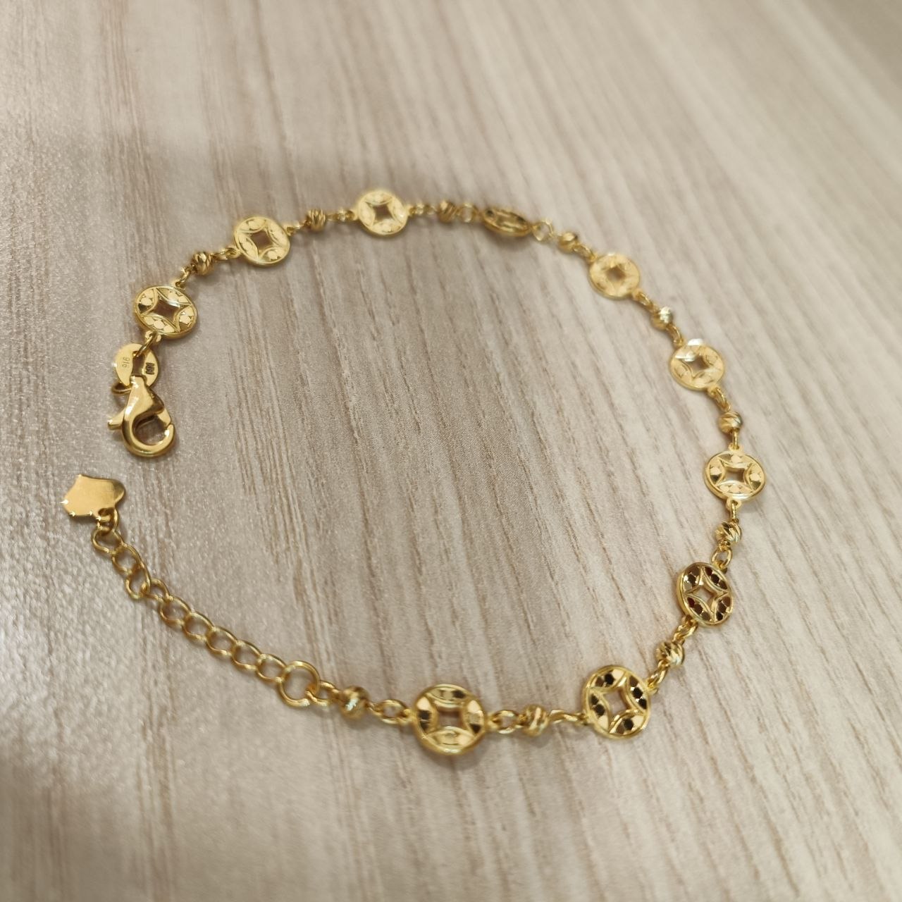 Adjustable 916 gold geometric round motif bracelet angled view