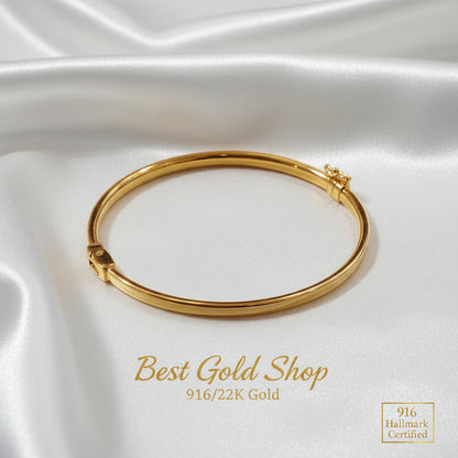 Detailed view of a polished 916 gold hollow shiny bangle