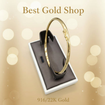 916 gold hollow shiny bangle shown on a jewellery display