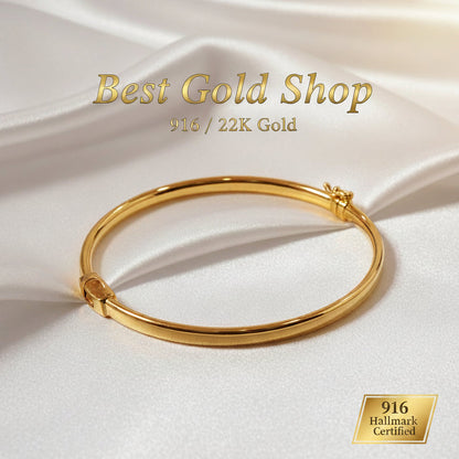 Standing view of a polished 916 gold hollow shiny bangle