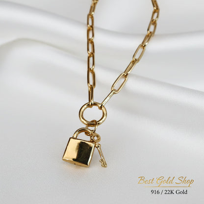 Close-up view of 916 Gold Lock & Key Paperclip necklace charms.