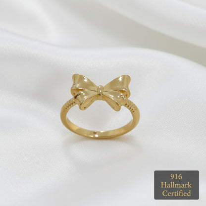 Close-up front view of polished 916 gold ribbon bow ring