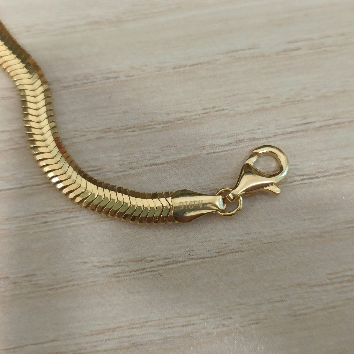 Full view of 916 gold snake chain bracelet