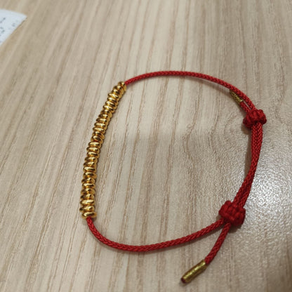999 gold bead strand bracelet with red adjustable cord - angled view
