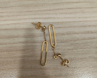 916 gold paperclip dangle earrings laid in opposite directions, showing open elongated drops and butterfly backs
