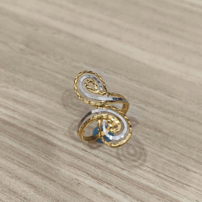 Front view of a 916 gold two-tone swirl ring with twin spiral details and textured gold edges on pale wood