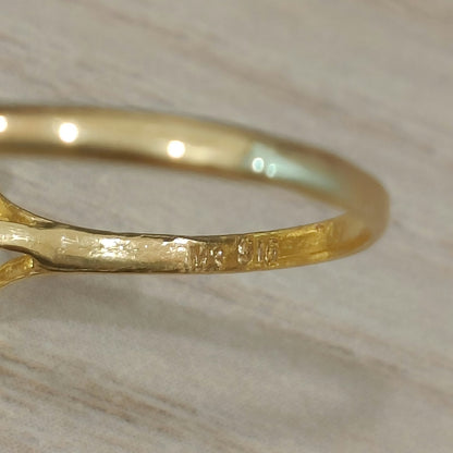 Close-up of the 916 stamp inside the gold band of a two-tone lotus ring