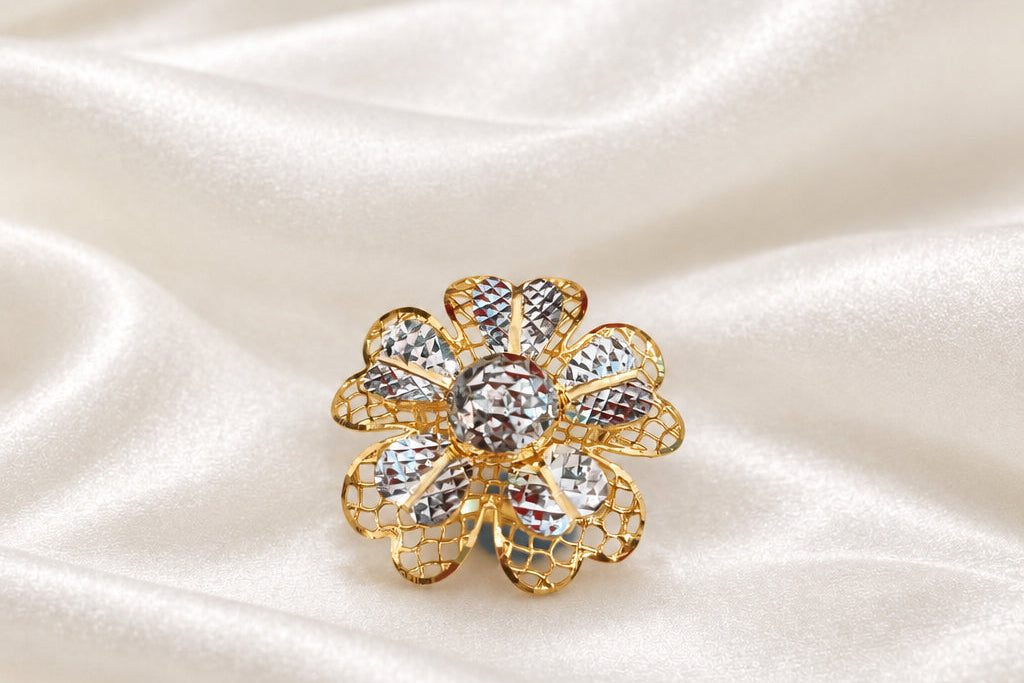 Front view of a 916 gold two-tone floral ring with patterned petals on cream satin