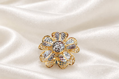 Front view of a 916 gold two-tone floral ring with patterned petals on cream satin