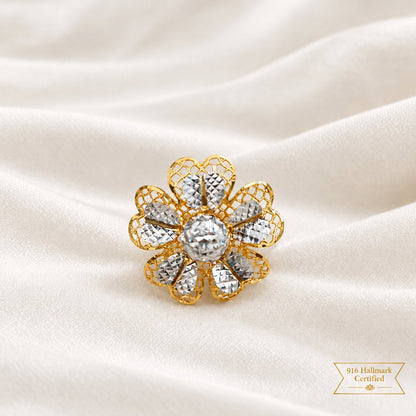 Close-up of a 916 gold two-tone floral ring showing faceted silver-colour petal details on cream satin
