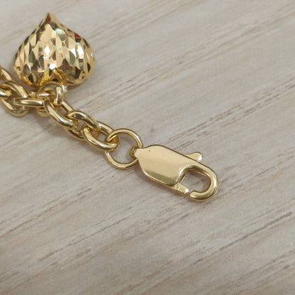 Close-up of the clasp, chain links and faceted heart charm on a 916 gold Wanzi bracelet