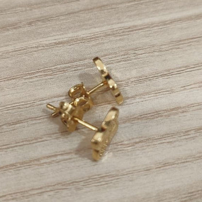 Side view of 916 gold four-petal flower stud earrings showing posts and butterfly push backs
