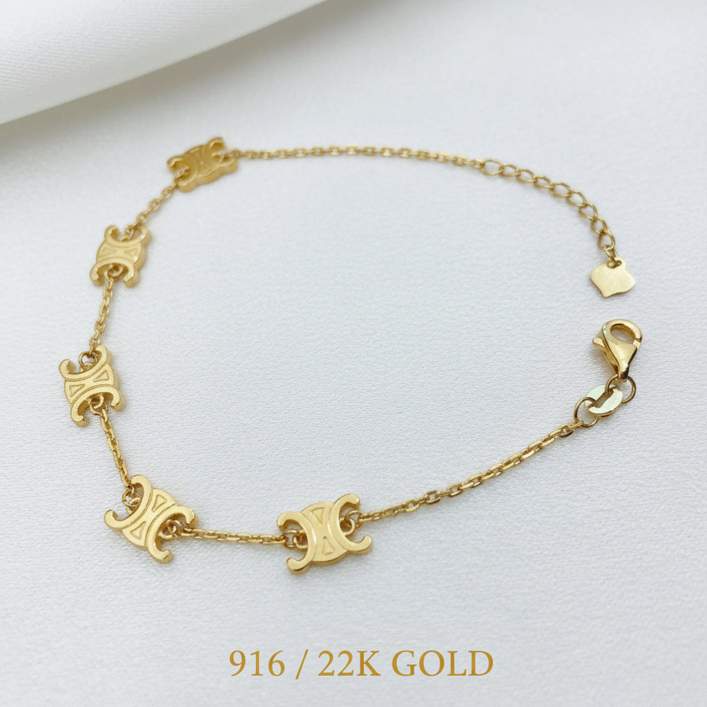Full open view of the 916 gold scroll link bracelet with five engraved motifs, lobster clasp and heart-tag extension chain