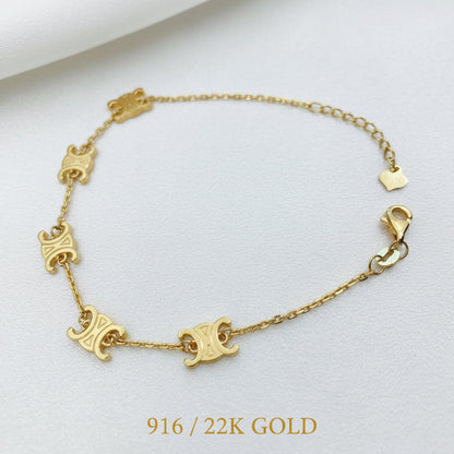 Full open view of the 916 gold scroll link bracelet with five engraved motifs, lobster clasp and heart-tag extension chain