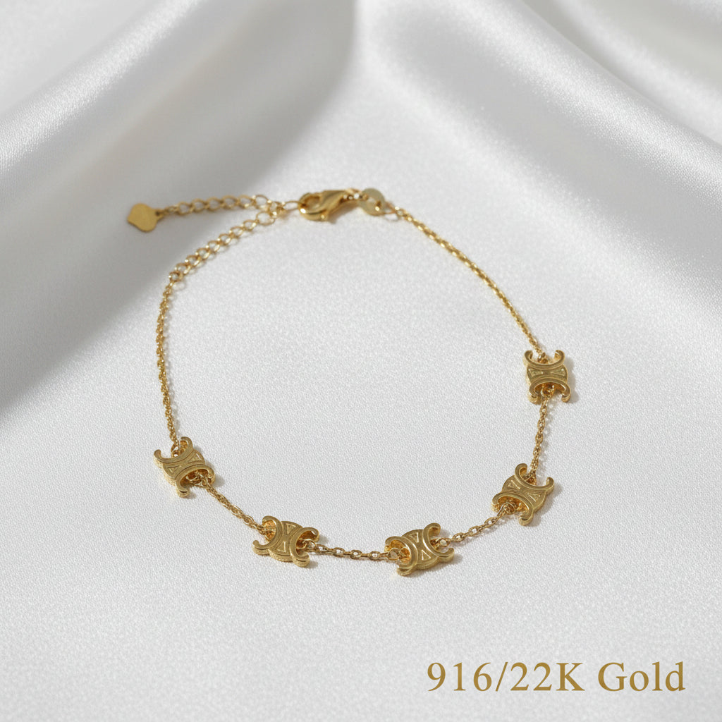 Angled full view of the 916 gold scroll link bracelet on white satin, with engraved curled motifs and extension chain