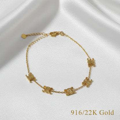 Angled full view of the 916 gold scroll link bracelet on white satin, with engraved curled motifs and extension chain