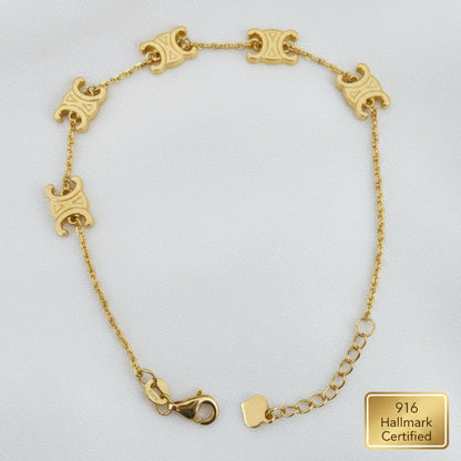 Top view of the 916 gold scroll link bracelet arranged in a long oval, with five engraved motifs and lobster clasp