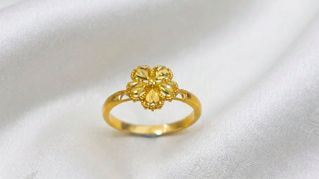 Front view of a 916 gold blossom ring with five faceted petals and beaded edges on white fabric
