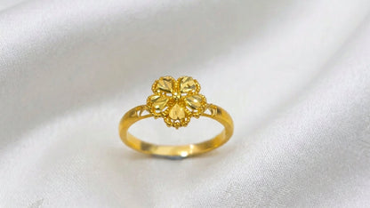 Front view of a 916 gold blossom ring with five faceted petals and beaded edges on white fabric