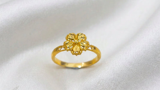 Front view of a 916 gold blossom ring with five faceted petals and beaded edges on white fabric