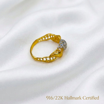Rear angled view of 916 gold two-tone twist ring showing the inner band, openwork sides and faceted silver-coloured centre