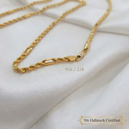 Close-up of the clasp, twisted rope sections and elongated links of a 916 gold Hollow Rope C necklace on white fabric