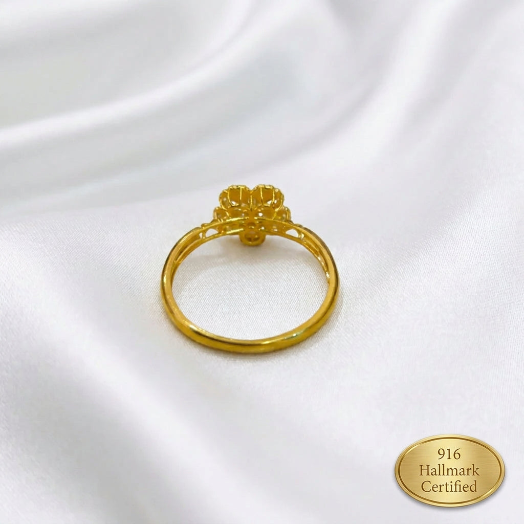 Rear view of the 916 gold blossom ring showing the circular band and raised floral setting on white fabric