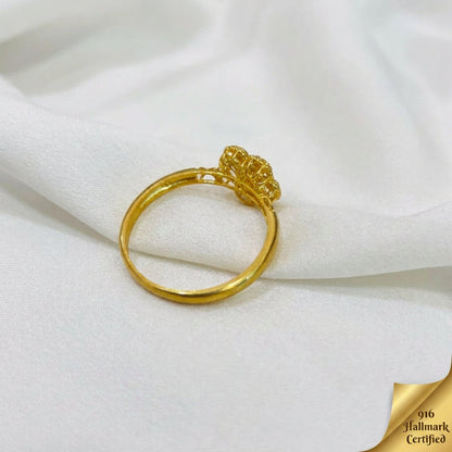 Side profile of the 916 gold blossom ring showing the raised flower and openwork shoulders on white fabric