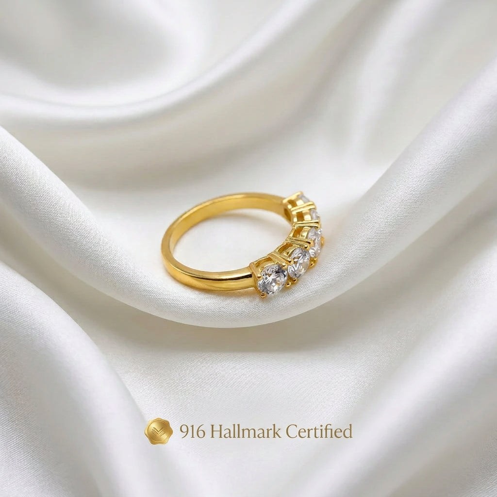 Angled side view of 916 gold eternity-style ring with round silver-coloured accents on white fabric